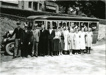 Standing, left to right, Ray Cool, operator; Rufus M. Cavendish, President of Board of Education; C. H. Conway, Principal of WSHS.  Students, Paul McCray, Bacel Chapman, Evelyn Malcomb, Orla Hinkle Lowther, Avis Collins, Eugenia Duke, Mabel Johnson, Ruby Luikart, _ , Mary Howell, Shirley Bruffy, Sudra Mace.  Students on bus: Leona Cunningham in driver's seat, Oleva Robinson, Ersel Robinson Rohrbaugh, Thelma Powers, Virginia Hartman.  At last window are Ruth Snyder and Maynard McMillion.  Other bus students included Oral Gene Anderson, Almond Arbogast, Obert Claypool, Harold Cowger, Loran Jordan, Beatrice Mace, Charles Westfall of Cleveland.