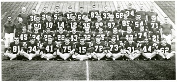 'First Row, left to right: George Zukas, Jim Salentro, John Holstein, Ed Linder, Mark Hannah, Bill Lemak, John Russell, Gary Thall, Steve Edwards and Steve Wilson.  Second Row:  Rusty Starford, Del Gainer, Pete Secret, Jerry Phillips, Fred Kolana, Dick Melkerson, Sam Bellotte, Jim Bosley, Darrell Perry, John Shelton and Tyrone Harris.  Third Row:  Assistant Coach Francis Nickler, Head Coach Ed Shockey, John Kenna, Bob Zambo, Tom Digon, Joe Manchin, Gene Brown, Rochie Pendley, Joe Pendry, Bob Podbesek, Ted Easterling, Nelson Edwards and Assistant Coach Ernie May.  Fourth Row:  Assistant Denny Douds, Scott Criss, Bob Cummings, Jim Sheppard, Charles Wood, Tome Kucer, Emo Schupbach, Mike Germak, Lou Sieminski, Tom Casto, Assistant Coach Fred Hauff and Assistant Coach Tom Tucker.'