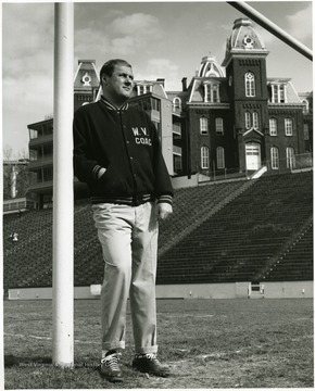 Coach is standing on Mountaineer field below Woodburn Hall.