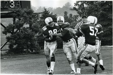 Players surround Oscar Patrick after he scores for WVU.