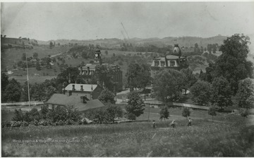 'W. V. University Campus taken from Hill now occupied by Womens' Hall. Small building with little spikes on the corners, over the roof of Fife cottage was original Armory later converted into Experiment Station. Taken in late 80s.'