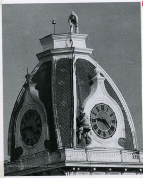 Two workers are cleaning Woodburn Tower, Woodburn Hall, West Virginia University.