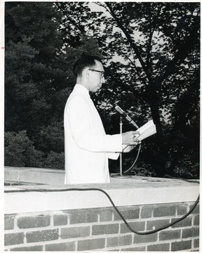 Gregory Van Camp speaking at a microphone.