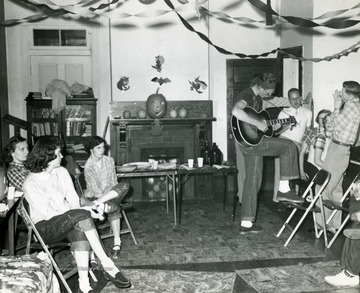 Man with a guitar entertains the group.