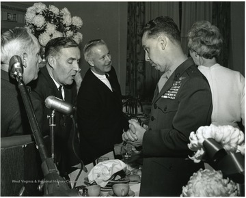 'Feb. 13, 1967 WVU Birthday Dinner, from left to right: Ray Wilkins; Joe Gluck, WVU Director of Student Affairs; Congressman Arch Moore; Marine Corps Brig. Gen. and WVU alumnus General Earl E. Anderson.  Woman with back turned is unidentified.'