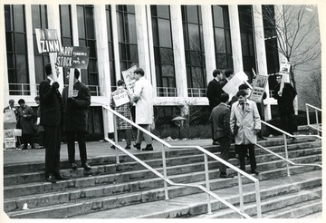 Students with candidate signs on voting day in front of Mountainlair.