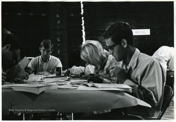 Students working on their registration forms in the Field House on Beechurst Avenue.