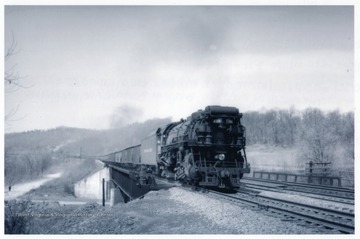 'With empty coal train headed for Peach Creek Yard on Local subdivision.  Seen here crossing the Mudd River Bridge at Barboursville, W. Va. April, 1951.'