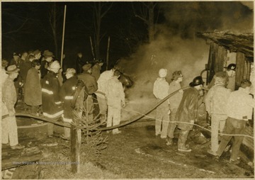 Police, firemen, and spectators at the scene of a fire in Wilsonburg.