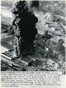 'A million dollar fire destroyed four acres of buildings of the General Storage Company and Mountain State Fabricating Company here yesterday. Intense heat and smoke prevented fireman from bringing the fire under control, a number of buildings were dynamited to keep the blaze from spreading. To the right is a Vets hospital which was in danger for a while. (AP WIREPHOTO) (WFS 60700STF-WFS)1952.'