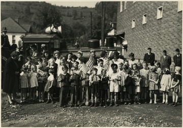 Children hold little American Flags at Wolf Summit. Likely the dedication ceremony. 