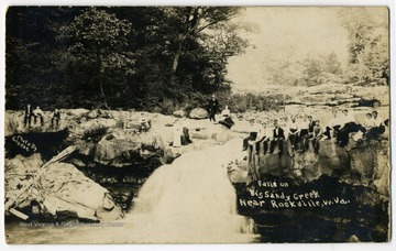 At a fall on Big Sandy near Rockville, W.Va., visitors perched on edges of rock formation. 