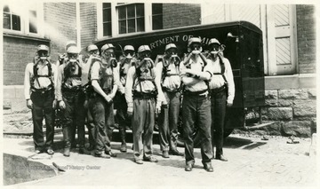 A photograph of men in safety gear, wearing breathing equipment.