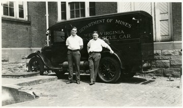 A photograph of two men standing in front of the West Virginia Mine Rescue Car from the Department of Mines.