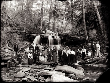 A portrait of people at the bottom of a waterfall.