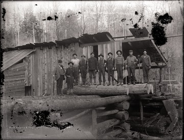 A view of loggers with tools at lumber mill.