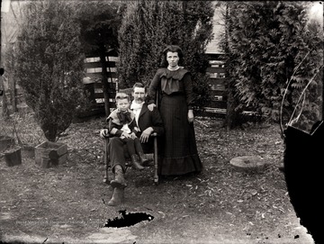 A portrait of a couple and a boy taken in the yard.