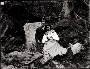 A portrait of a couple taken at the foot of a tree.