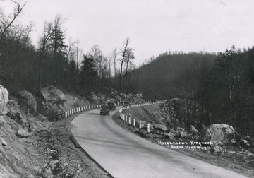 A view of several automobiles going down on the state highway. Print number 1715.