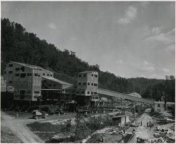 In the bottom right of the portrait, mine workers are laying down railroad tracks. 