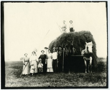 On the load, Nellie Schroth Aegerter, Louis Haslebacher. Standing left to right, Frieda Aegerter Stadler, unknown, Olga Aegerter Holtkamp, Lena Haslebacher Burky, Paul Aegerter, unknown. Children unknown.