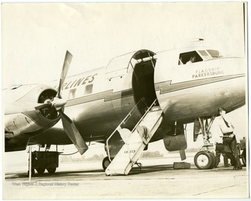 Propeller-powered American Airlines passenger aircraft on airport runway accepting passengers. 