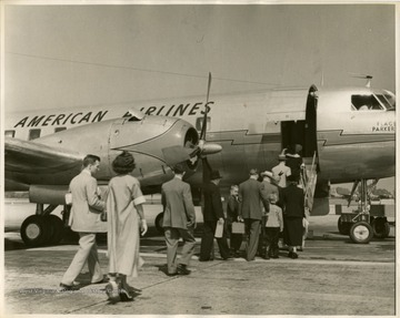 Propeller-powered American Airlines passenger aircraft on airport runway accepting passengers. 