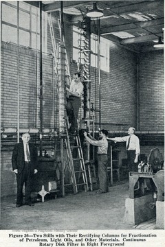 Two stills with their rectifying columns for fractionation of petroleum, light, oil and other material. Continuous rotary disk filter is in the foreground