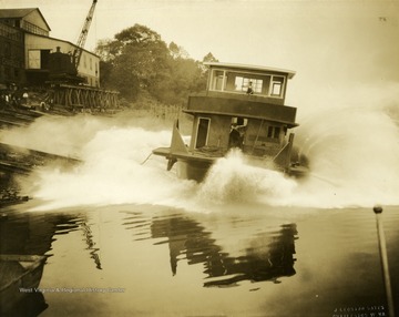 Launching of the towboat "Geo T. Price". This ship was built by the Charles Ward Engineering Works in Charleston, West Virginia. Note how the men on board brace themselves during the launch.