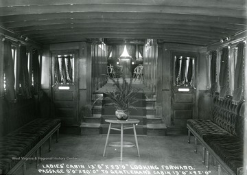 Cabins separated by gendered. The Ladies cabin is in the foreground and the Gentlemen's cabin is forward through the passage on the steam boat "Deal" built by The Charles Ward Engineering Works in Charleston, West Virginia.