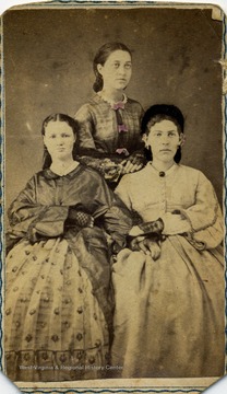 A carte de visite of three unidentified women dressed in Civil War era fashion and hair style.