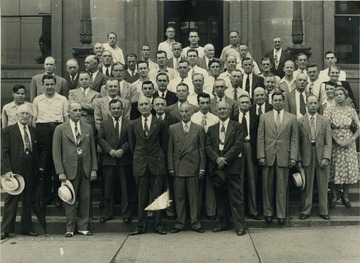 Unidentified Post Office employees pose on the front steps of the Post Office on High Street in downtown Morgantown.