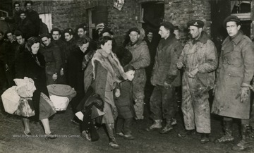 Information on back of photo reads: "Shame, guilt, and humiliation cloud the faces of these German women as they pass through the Canadian lines to an evacuation centre. They put guns before butter in the years between the wars; they lived on the loot of conquered Europe, and clothed themselves in furs from Russia and fine clothes from Paris. Now it is their turn to be homeless, and the watching troops, who saw grim evidence of German ruthlessness in the countries they liberated, show no sympathy."