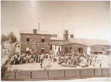 Workers stand outside of D. E. Abbott: "Manufacturer of Picture Frames and Mouldings. Portraits of All Kinds and Sizes."