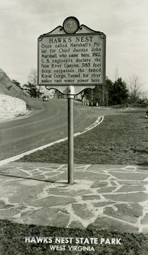 Sign on photograph reads: "Once called Marshall's Pillar for Chief Justice John Marshall who came here, 1812. U.S. engineers declare the New River Canyon, 585 feet deep, surpasses the famed Royal Gorge. Tunnel for river makes vast water power here." (From postcard collection legacy system.)