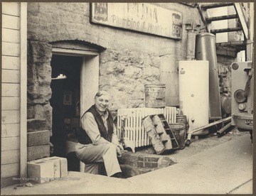 Buda poses outside his business establishment. Note the 4 digit phone number on the sign