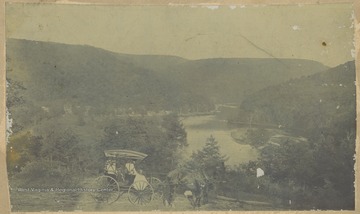 A family admires the picturesque view of the river from their horse-drawn carriage.