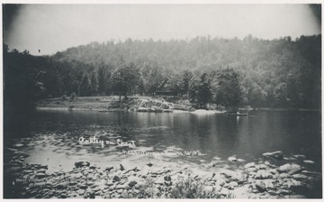 A man rows his canoe back to waiting spectators on the rocks along the river.