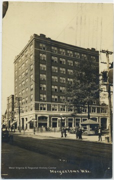 A building towers over a mostly empty street. See original for correspondence. 