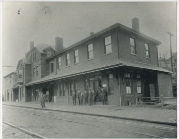 Unidentified men wait outside the "Lunch Room" for the next train.