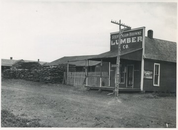 A pile of wooed is laid next to the store building.