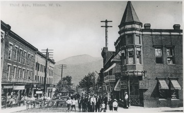 View looking northwest onto the street. A group of boys and men group in the street beside a horse drawn carriage. Subjects unidentified. Original postmarked June 12, 1912. 