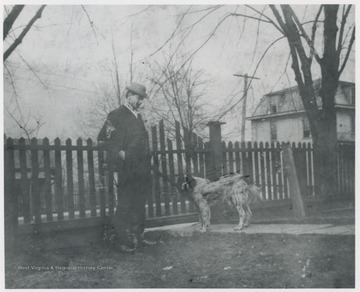 Murrell pictured in his yard with a dog. The house is located on the corner of 5th Avenue and Summers Street. C&O Commissary is pictured in the background. 