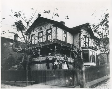 The family is pictured in their yard. Two of the children are identified as John and Tom Faulkner. 