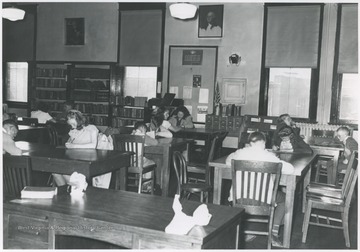 Students take the Golden Horseshoe Exam inside the building. Subjects unidentified. 