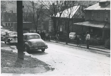 A group of people walking down the sidewalk. Carnegie Library pictured. 