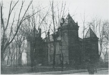 The building stands behind leafless trees, suggesting it is winter time. An unidentified man crosses the street on the right and walks toward the courthouse. 