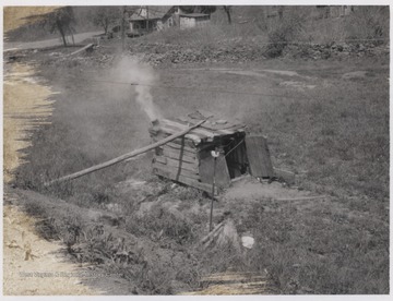 Smoke rises out of the small shack. 