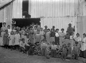 Kids in front row hold up apples.