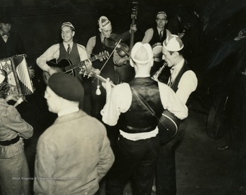 The group of musicians is likely the Rhythm Rangers. These musicians, like all employees of the "It's Wheeling Steel" radio broadcast, were either employees or family members of employees of the Wheeling Steel Corporation. This radio broadcast was company advertising executive John L. Grimes idea to promote both the company's product and its employees. It began broadcasting in 1936 and ended in 1944.